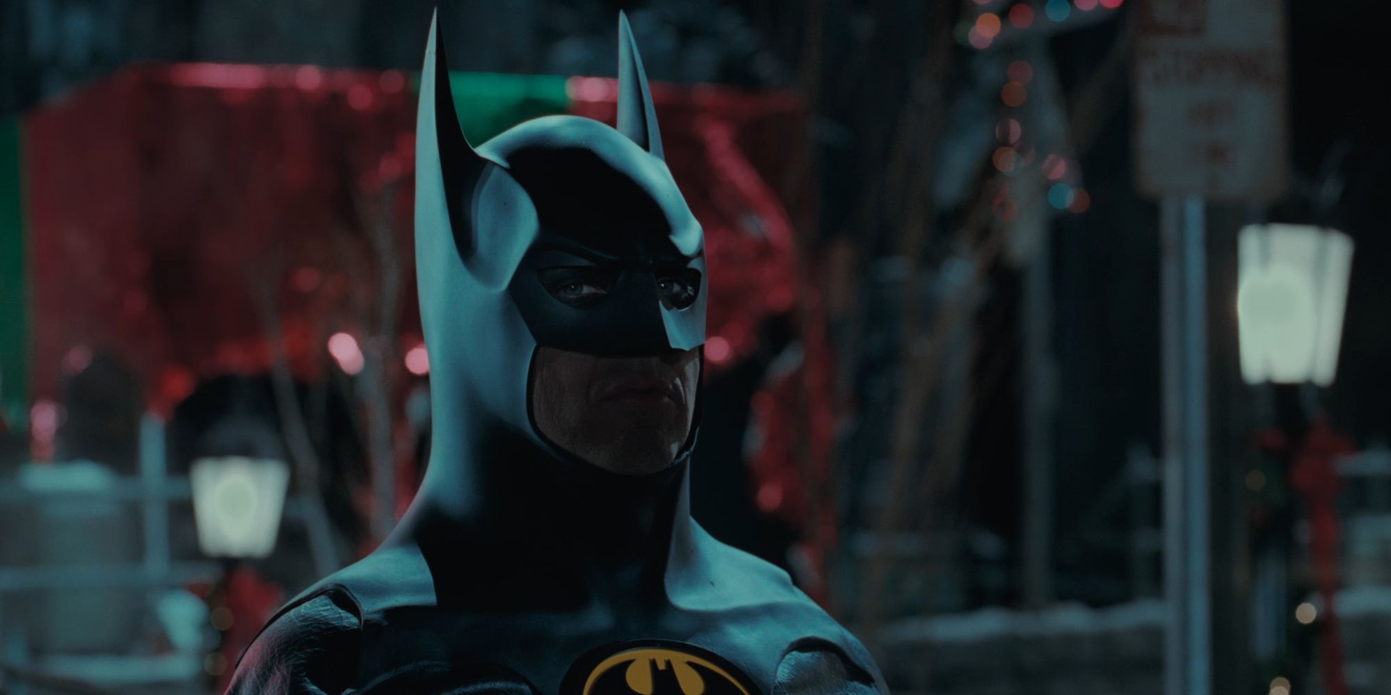 Michael Keaton as Batman glaring at a clown in Batman Returns