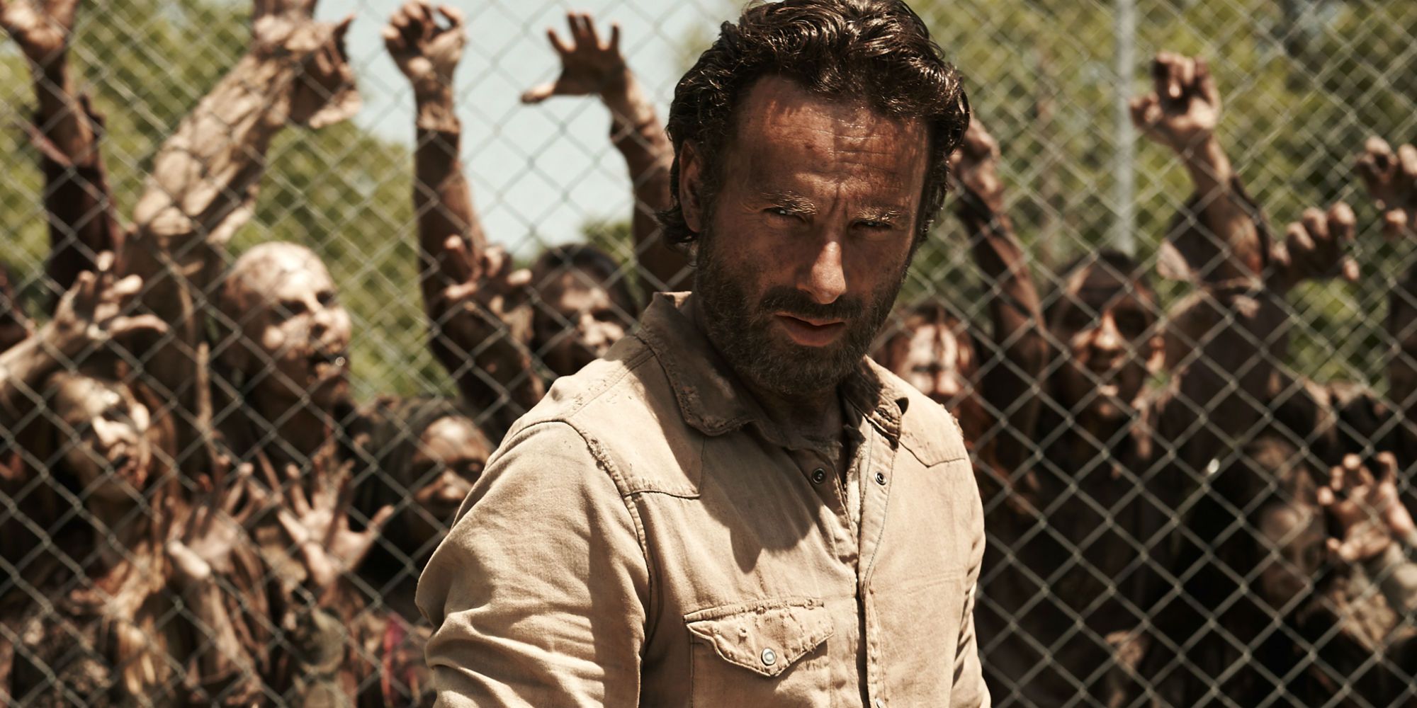 Rick Grimes walking away from a prison fence