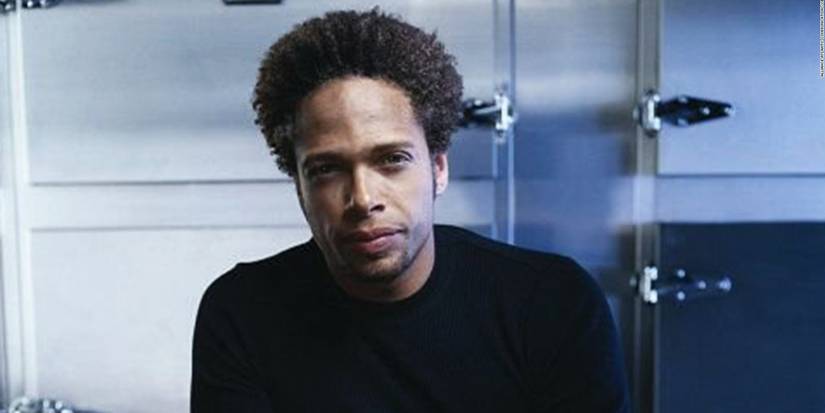 Warrick Brown as Gary Dourdan sitting in a medical examiner's room in CSI