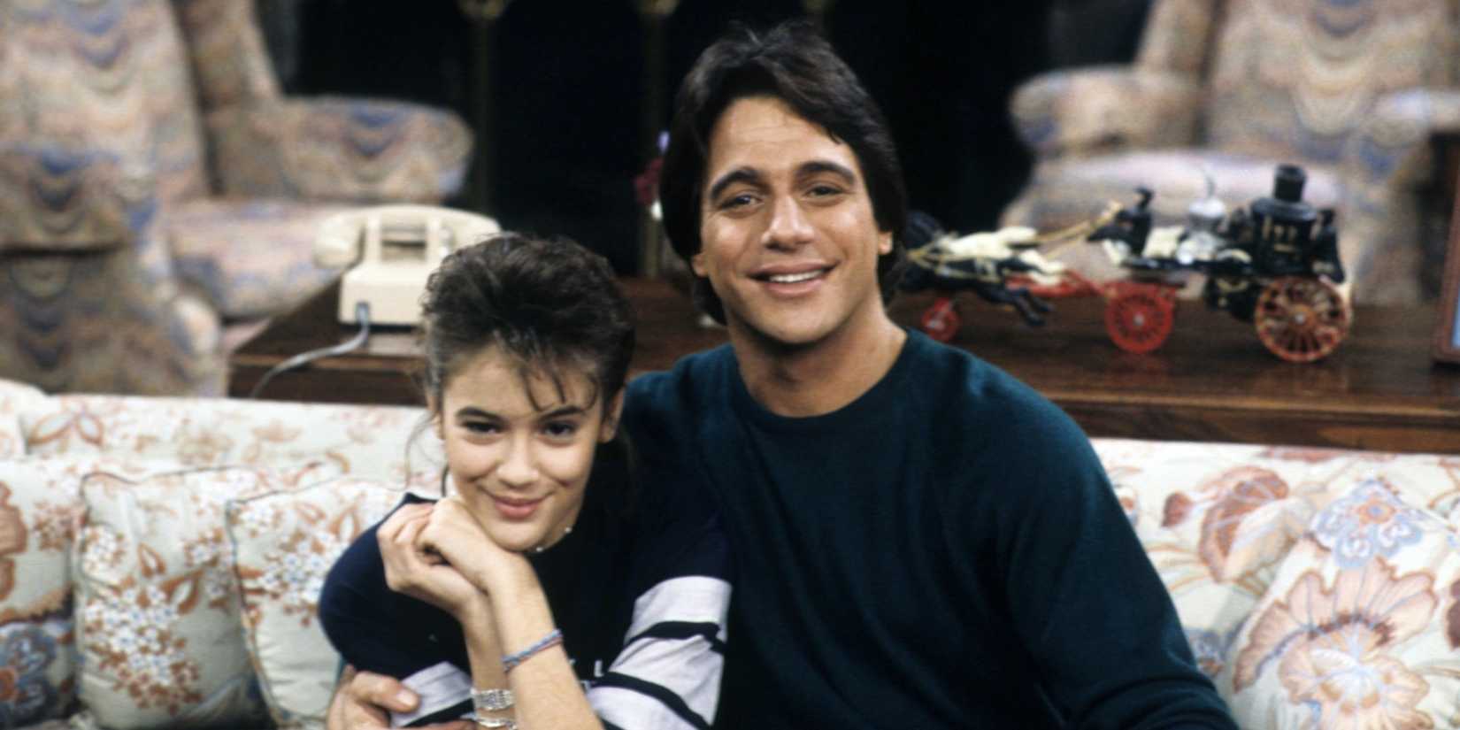 Alyssa Milano and Tony Danza sit on the couch on Who's the Boss