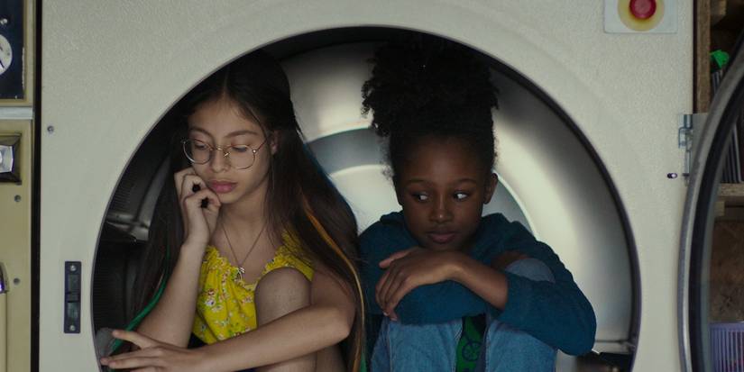 Две девочки, сидящие внутри чего-то, похожего на сушилку, в фильме Cuties