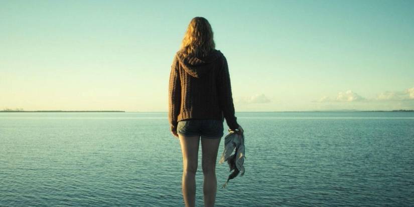 Jess (Melissa George) looking at the ocean, holding a dead seagull in Triangle (2009)