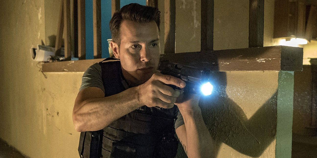 Antonio Dawson entering a building with a gun and flashlight