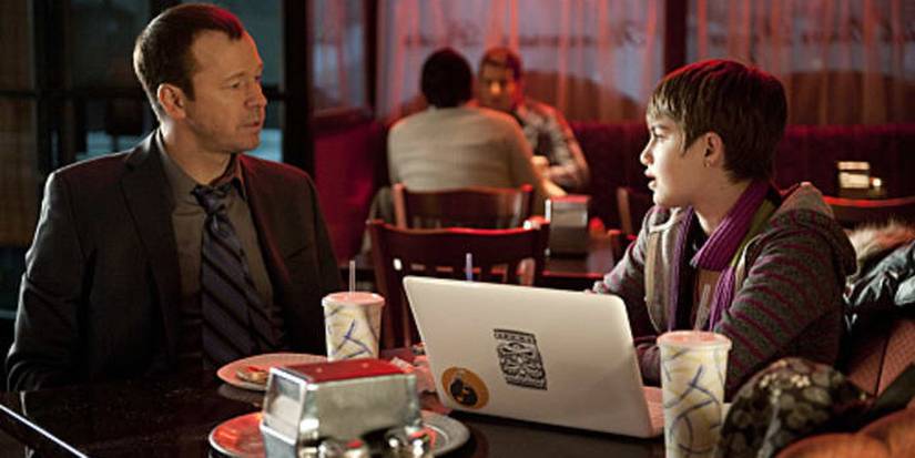 Danny and Nicky talking and sitting at a table in Blue Bloods