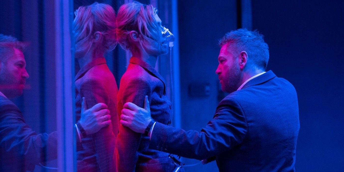A woman with an oxygen mask is grabbed by Kenneth Branagh in Tenet