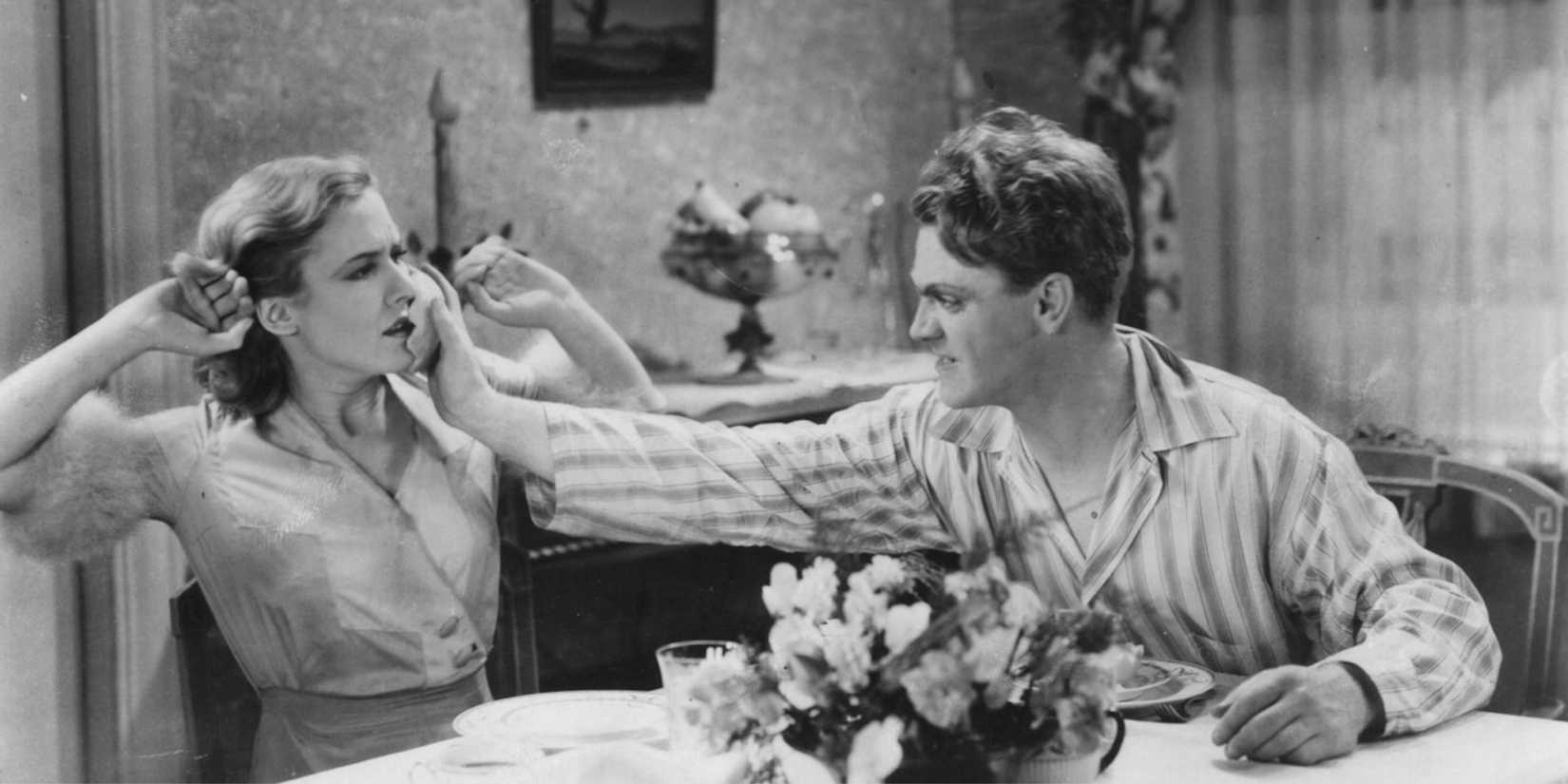 Mae Clarke and James Cagney as Kitty and Tom at the table in The Public Enemy