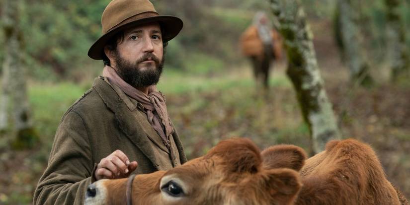 John Maguro in First Cow standing with a cow