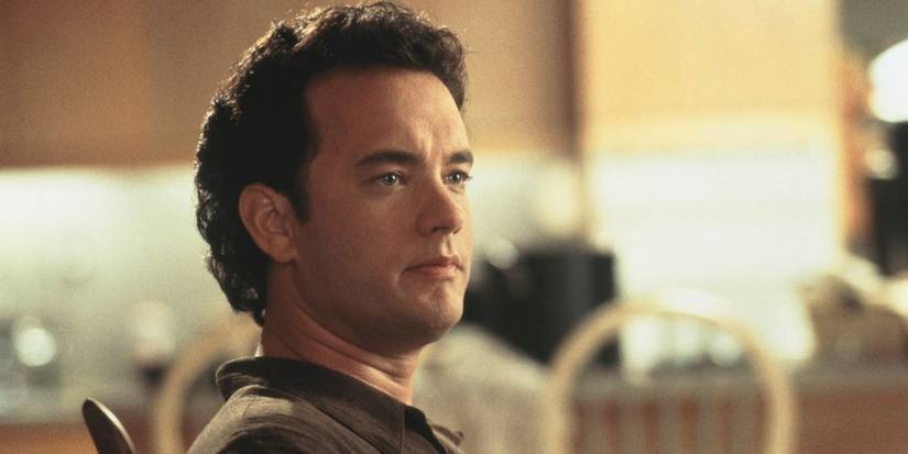 Tom Hanks as Sam looking serious while seated in Sleepless in Seattle