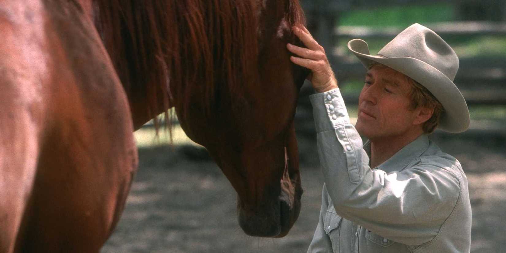 Robert Redford sussurrando para um cavalo no cavalo sussurro