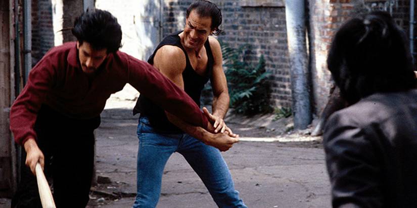 Steven Seagal grabbing a man's arm in an alley way in Above the Law