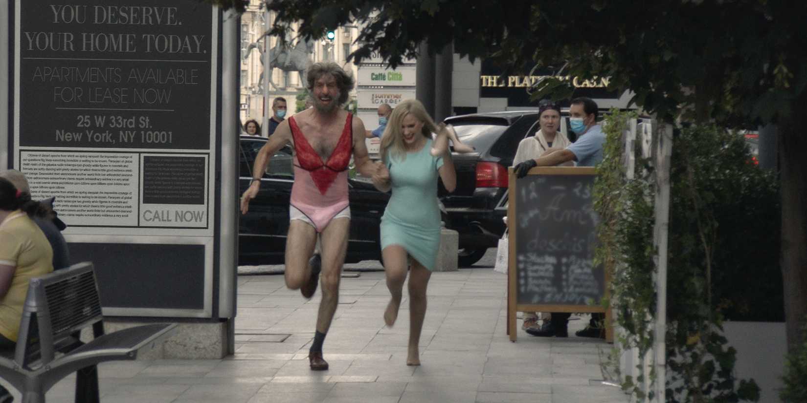 Sacha Baron Cohen and Maria Bakalova running down the street in Borat Subsequent Moviefilm