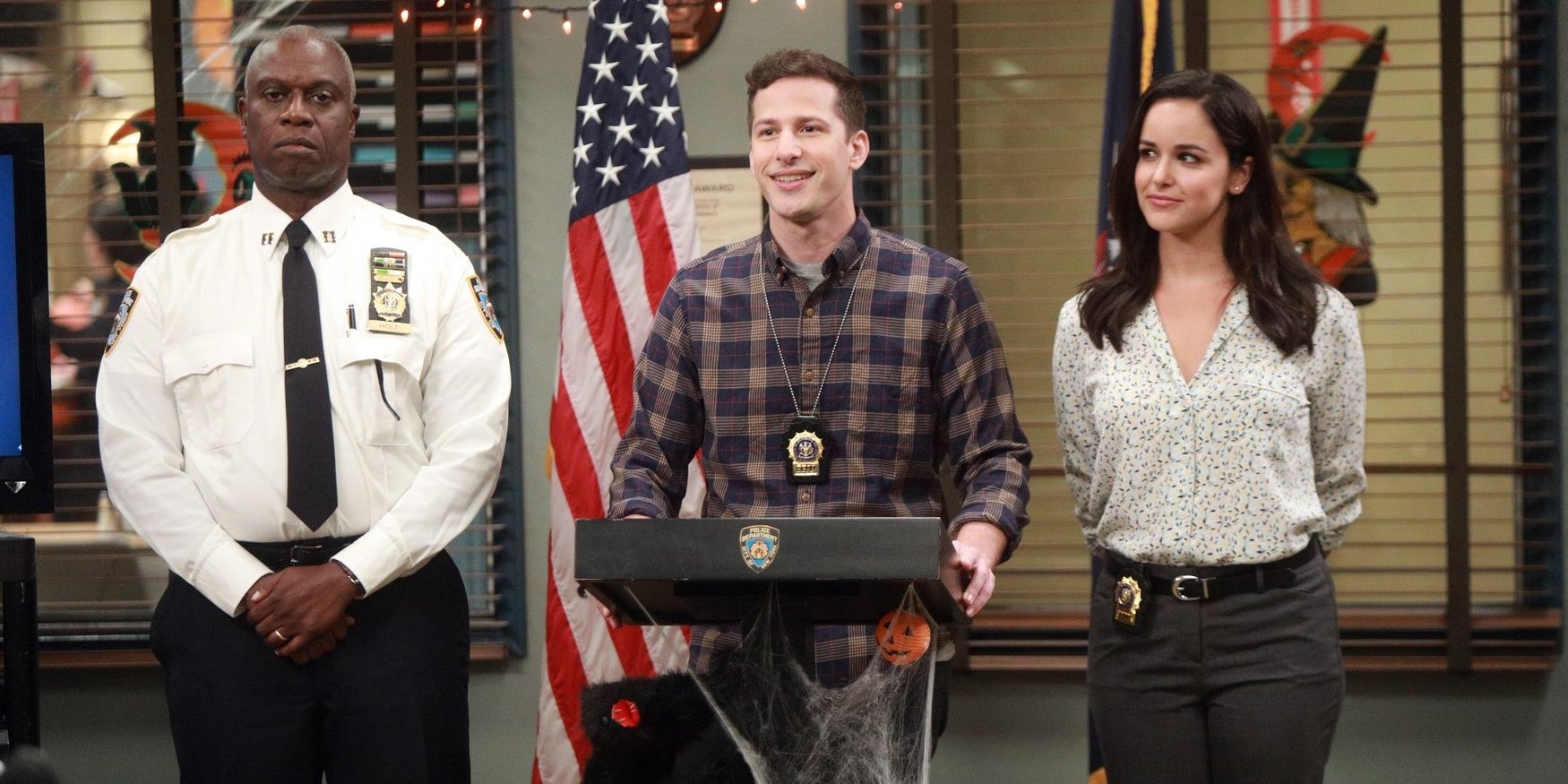 Holt, Jake, and Amy talking in a podium in Brooklyn Nine-Nine