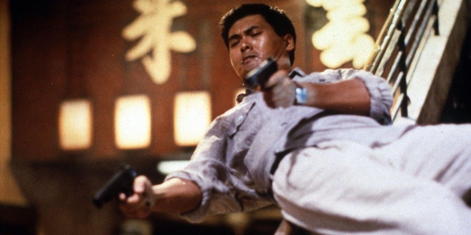 Chow Yun-fat sliding down a staircase with two guns in Hard Boiled
