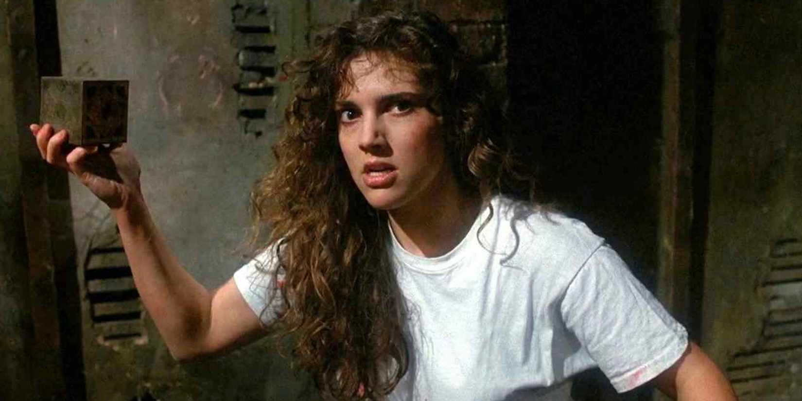 Ashley Laurence como Kirsty Cotton segurando a caixa de quebra-cabeça em Hellraiser