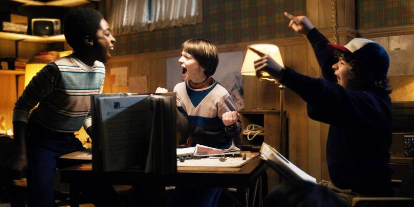 Lucas, Will, and Dustin celebrate while playing Dungeons and Dragons in Stranger Things
