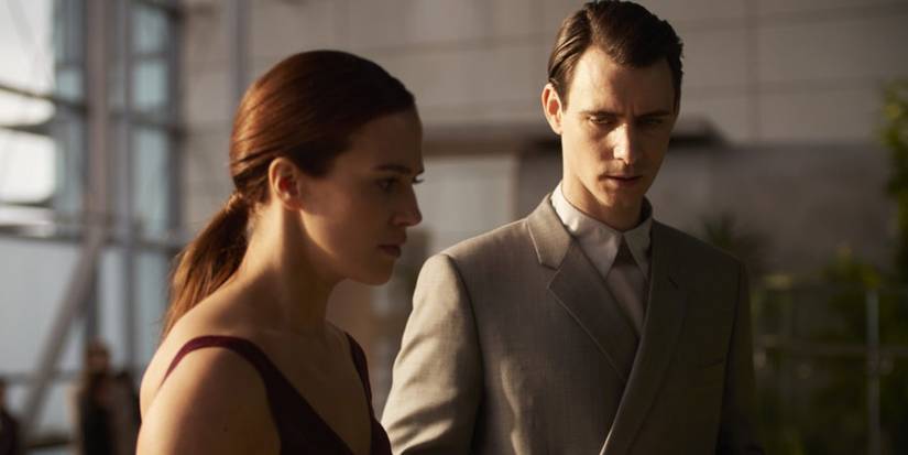 Jessica Brown Finlay as Lenina standing with Harry Lloyd as Bernard in Brave New World