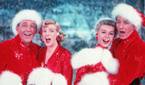 Bing Crosby as Bob Wallace, Rosemary Clooney as Betty Haynes, Danny Kaye as Phil Davis, and Vera-Ellen as Judy Haynes dressed in Santa costumes in White Christmas