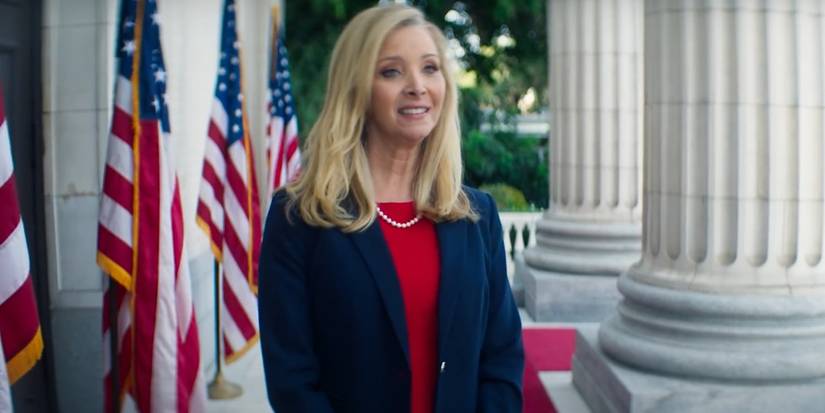 Jeanetta Grace Susan (Lisa Kudrow) smiling nervously in Death to 2020 on Netflix