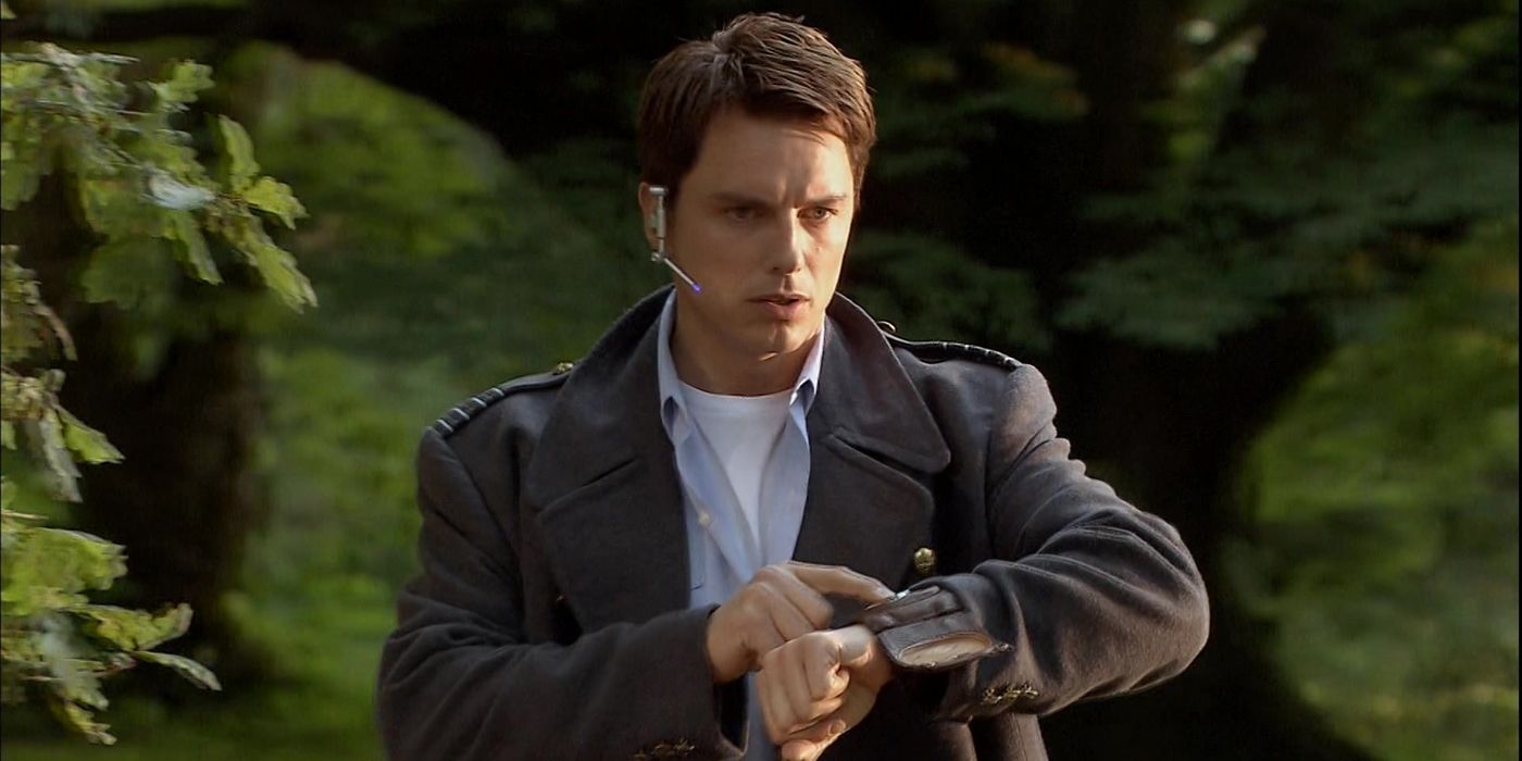 John Barrowman as Captain Jack Harkness in Doctor Who looking serious as he presses something on his wrist