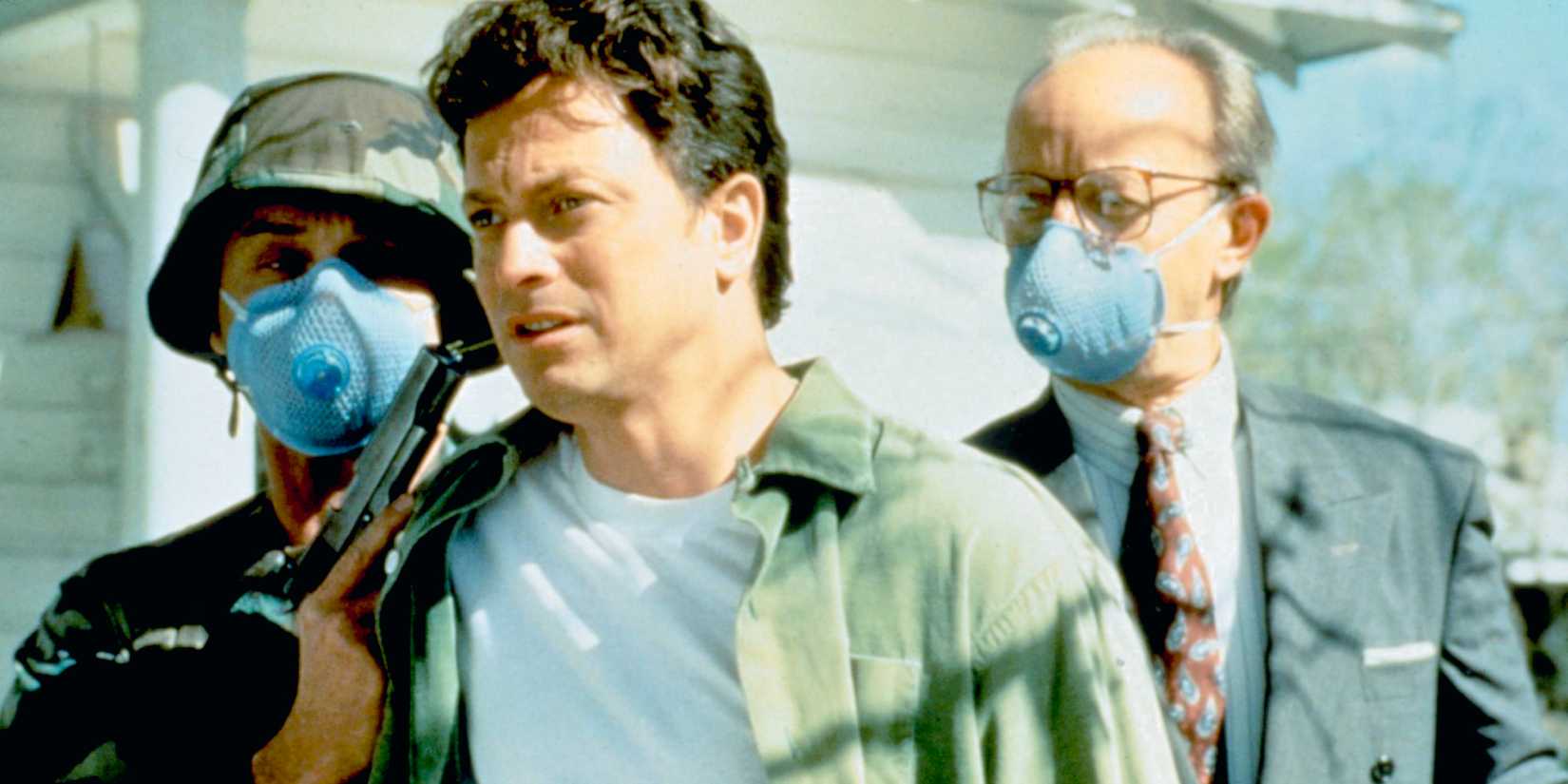 Gary Sinise como Stu Redman na versão de minisséries de 1994 de The Stand Standing ao lado de indivíduos mascarados