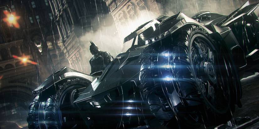 Arkham Knight showing the Batmobile parked in a Gotham City street with the Dark Knight stood to the left of it.