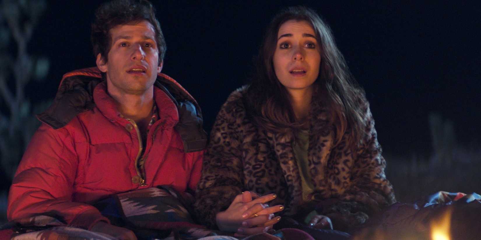 9 Movies Overlooked At The 2021 Awards 2 Andy Samberg as Nyles and Cristin Milioti as Sarah Wilder holding hands by a fire in Palm Springs