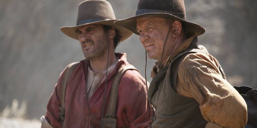 An Underrated Western Gem With Stellar Ensemble Cast 1 Joaquin Phoenix and John C. Reilly looking at something in The Sisters Brothers