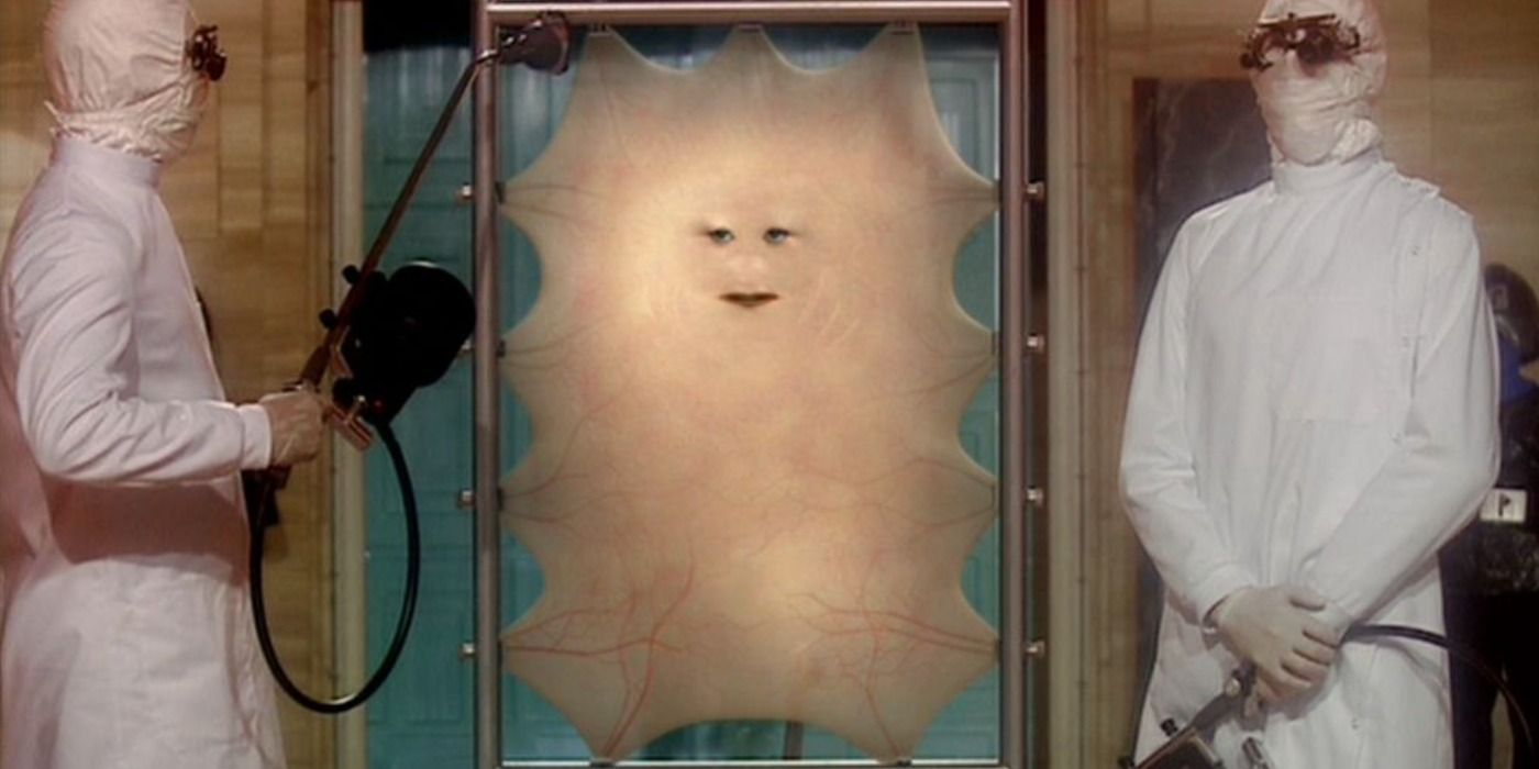 An assistant steams Cassandra, the last human alive who is just skin and a face attached to a metal frame, in Doctor Who season 1.