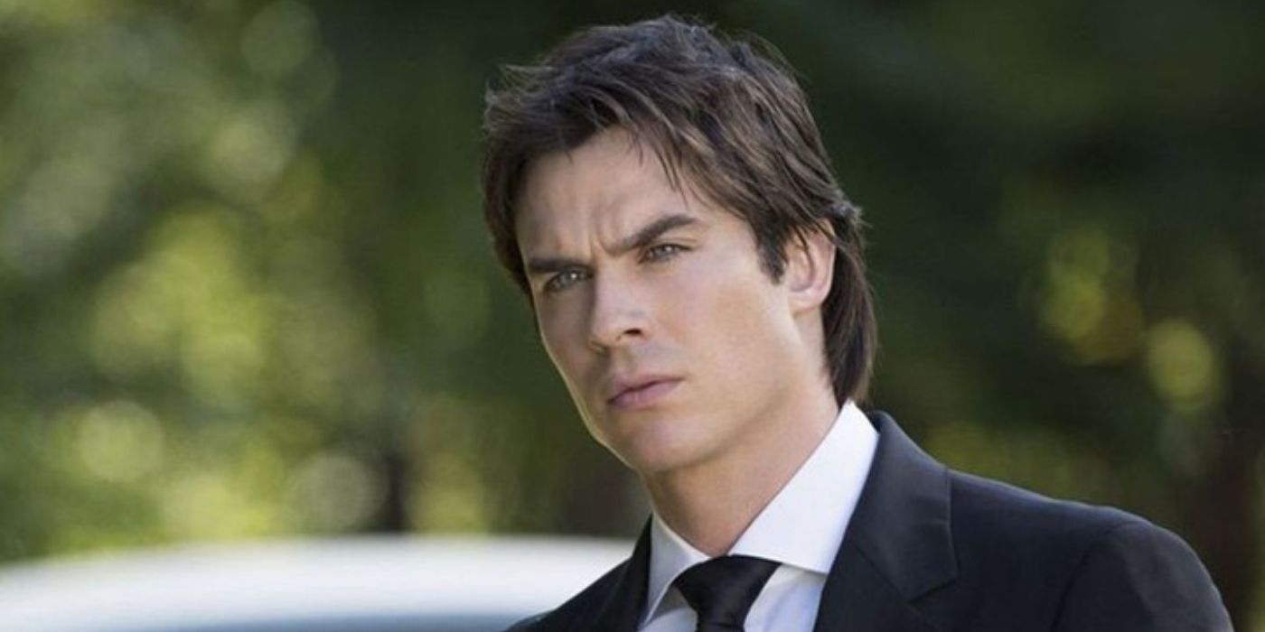 Vestido em um terno e ao ar livre, Damon Salvatore olha