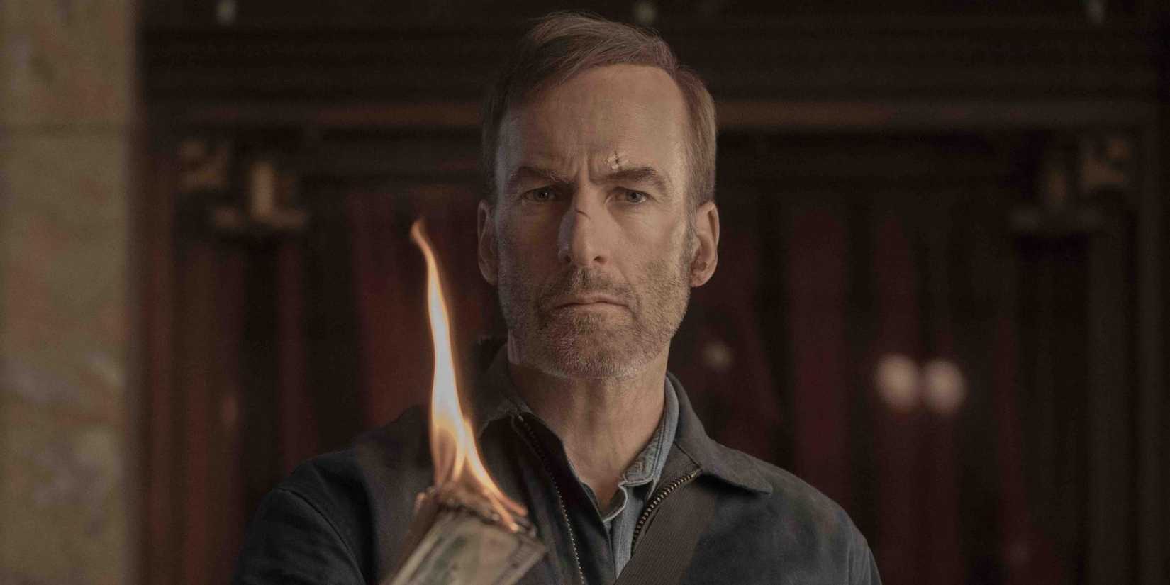 Hutch olha fixamente enquanto segura uma pilha de dinheiro queimando em Nobody