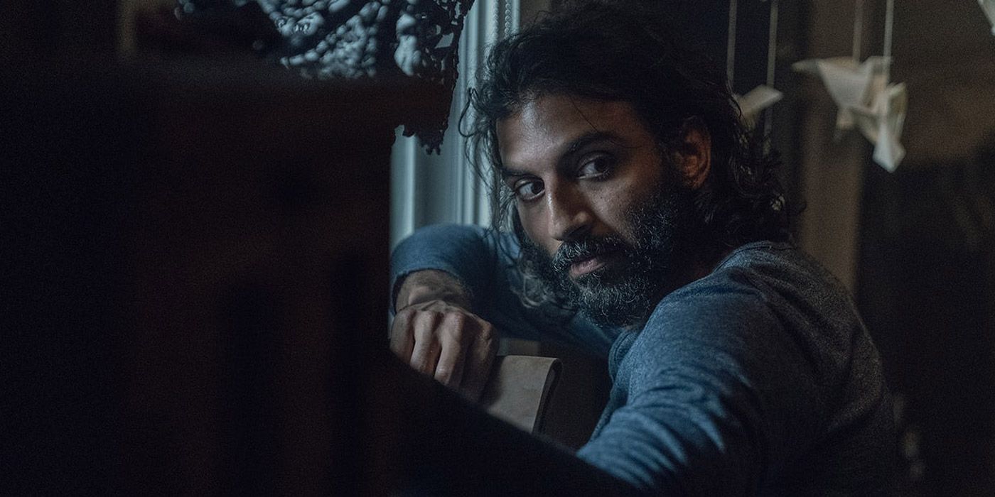 Avi Nash as Siddiq standing near a window in The Walking Dead