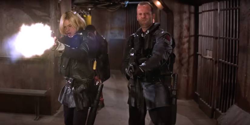 Jason Statham and Clea Duvall as Jericho and Bashira firing guns in Ghosts of Mars