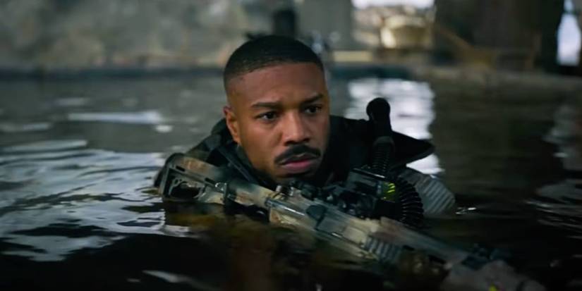 Michael B. Jordan's John coming out of the water holding a rifle in Without Remorse