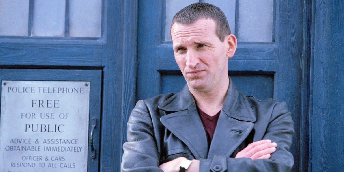 The Ninth Doctor with his arms crossed in front of the Tardis in Doctor Who