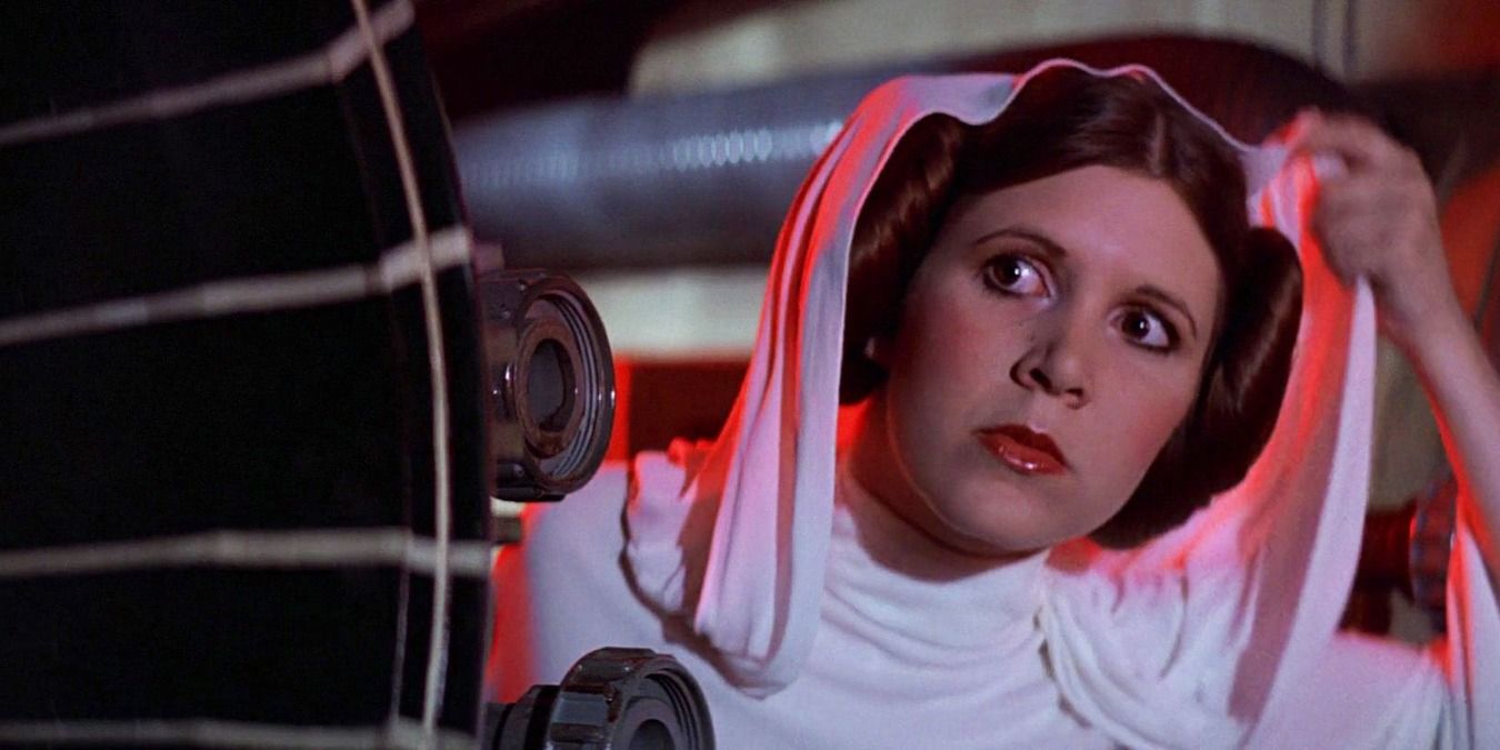 Princess Leia hiding behind a machine with her hood up