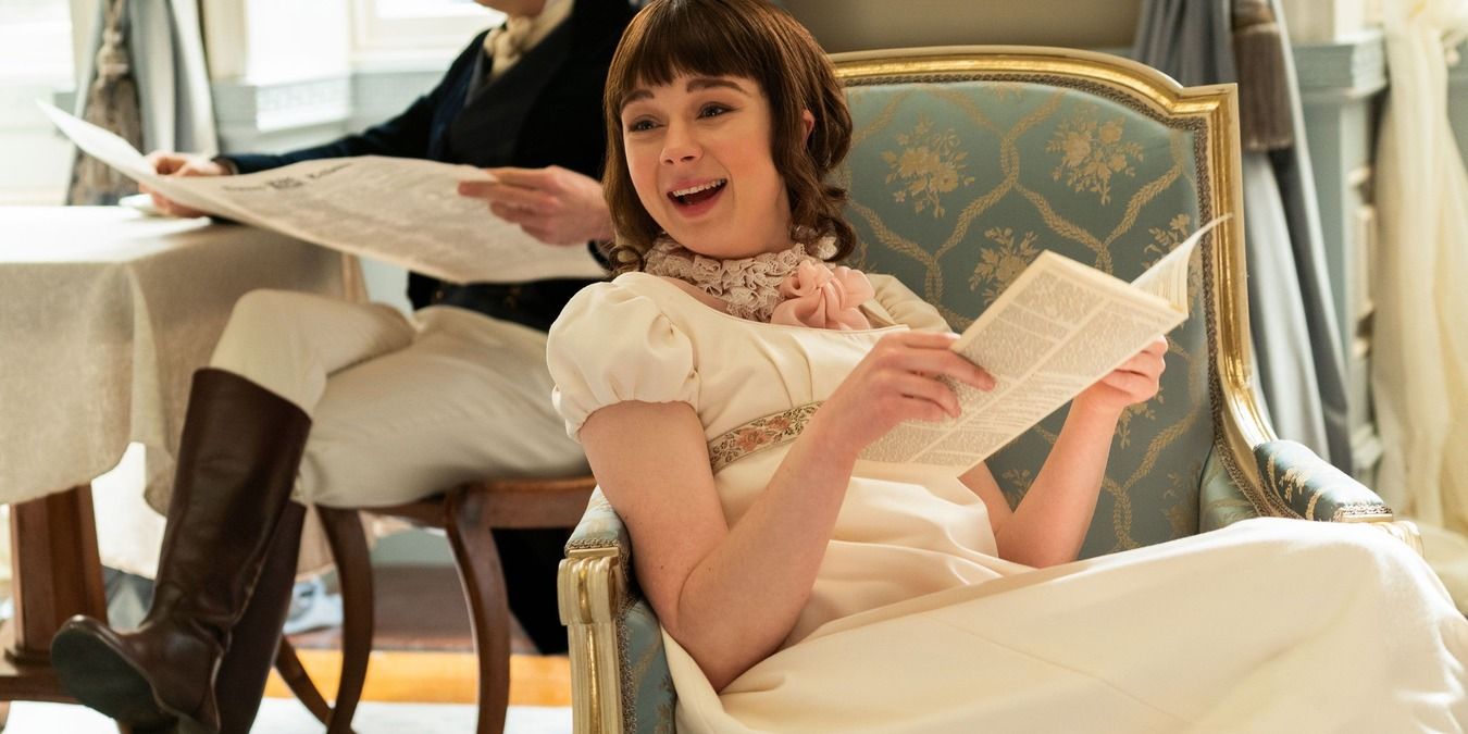 Eloise Bridgerton lying on a couch laughing while reading Lady Whistledown in Bridgerton