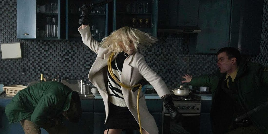 Loraine Charlize Theron fighting off policemen with a hose and a pan in a still from Atomic Blonde Cropped