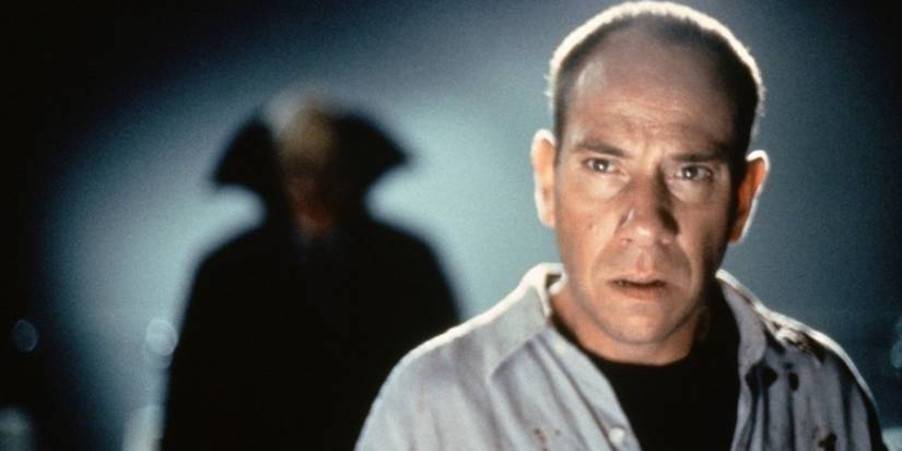 A vampire standing behind Miguel Ferrer in The Night Flier