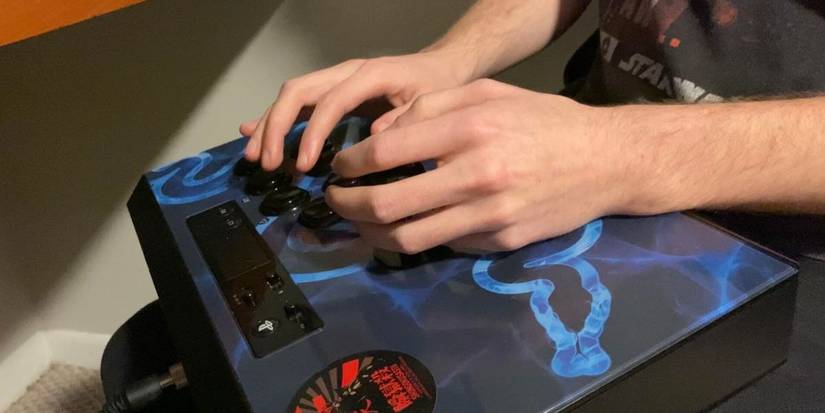 Closeup of a guy using an arcade stick.