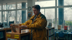 Jim Dooley holds a book titled Charlie the Choo-Choo in Lisey's Story