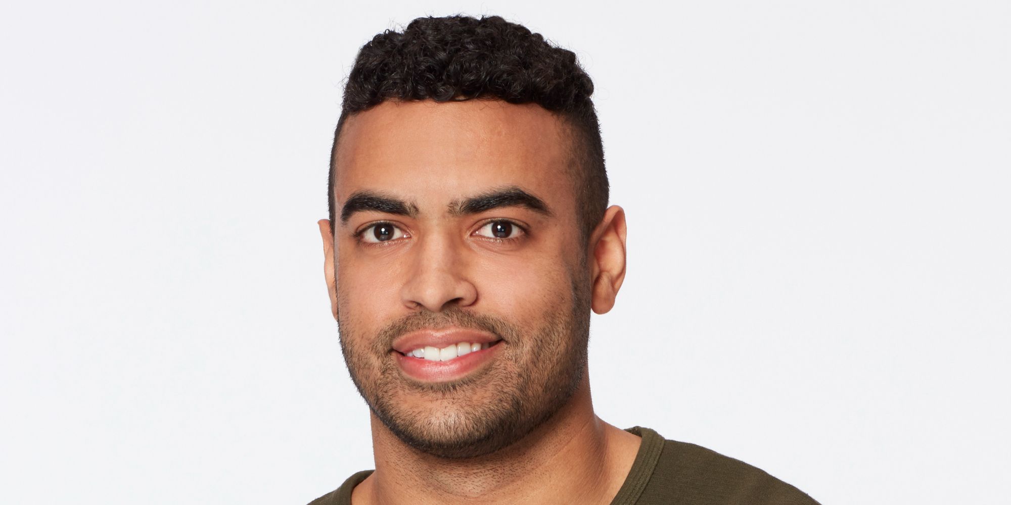 Justin Glaze on The Bachelorette season 17 smilin against a white backdrop
