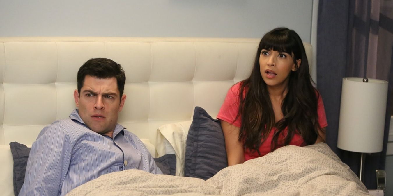 Schmidt and Cece in their bed looking over confused and startled