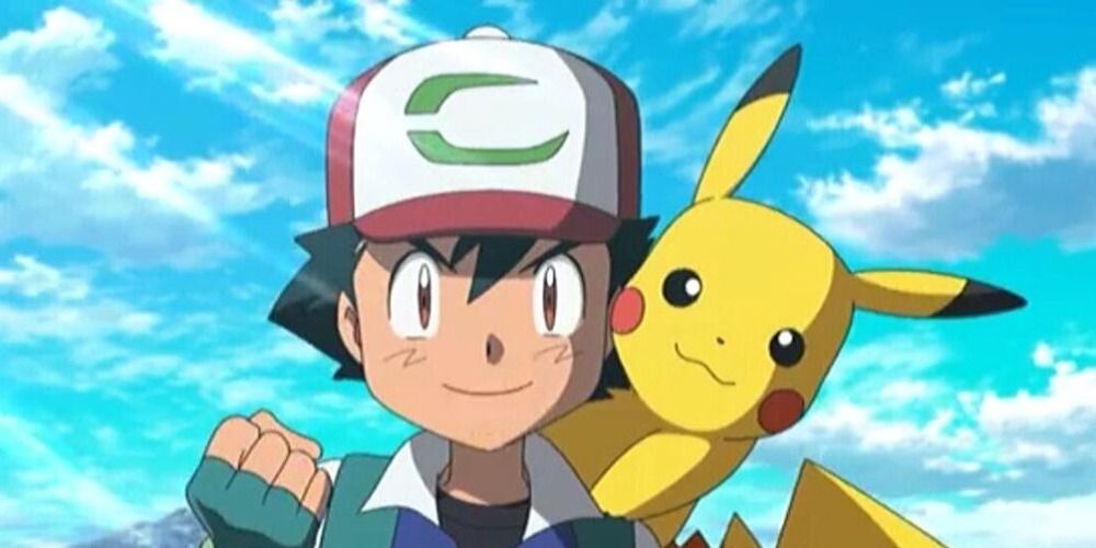 Ash Ketchum and Pikachu from Pokemon smiling at the camera in front of a blue sky