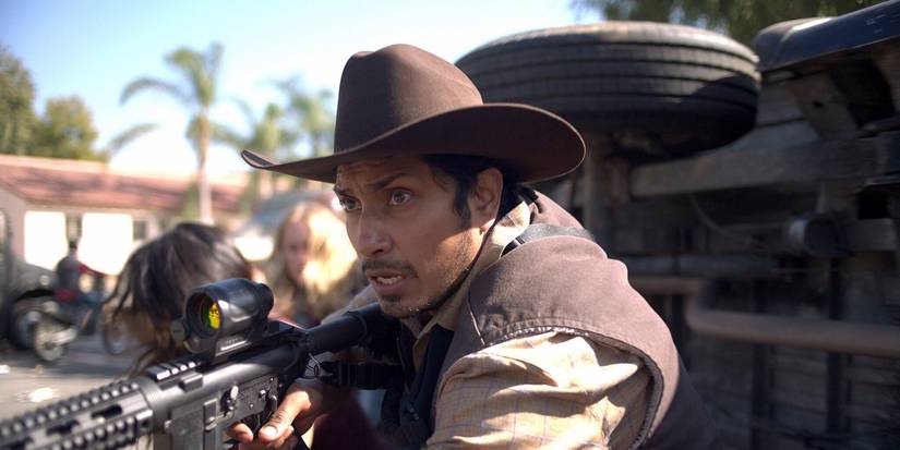 Муж в ковбойской шляпе с оружием в фильме "The Forever Purge"