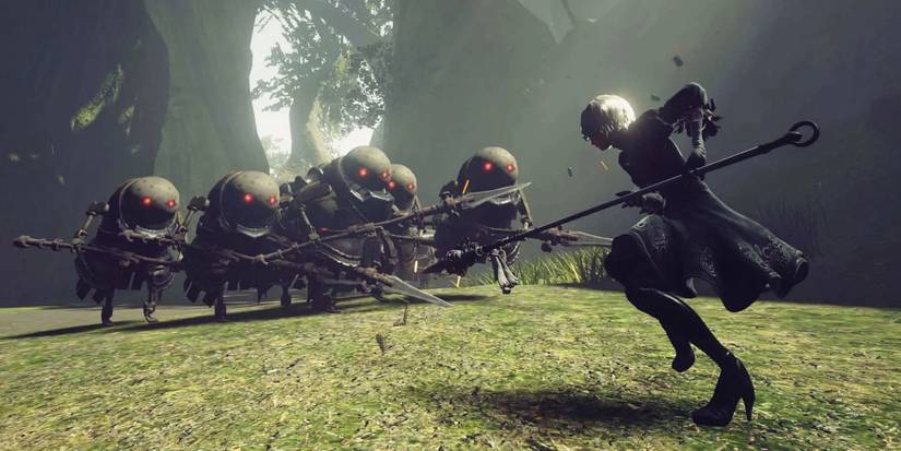 2B fights hordes of robot enemies in the forest of NieR:Automata.