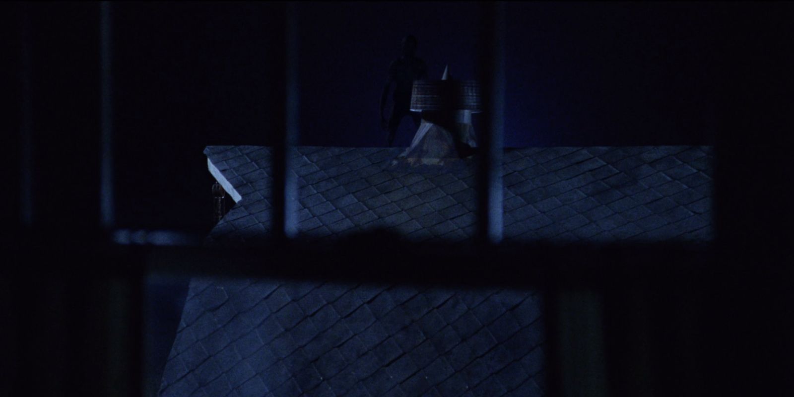 An Alien scout watches from a rooftop in Signs (2002)