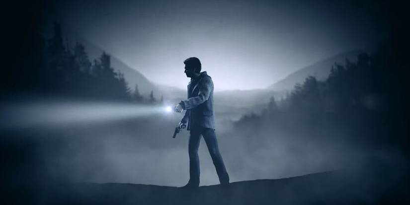 Alan points his flashlight in the dark woods in Alan Wake Remastered.