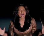 An overhead shot of Jennifer Hudson, singing passionately, hands out and eyes closed, from Dreamgirls.