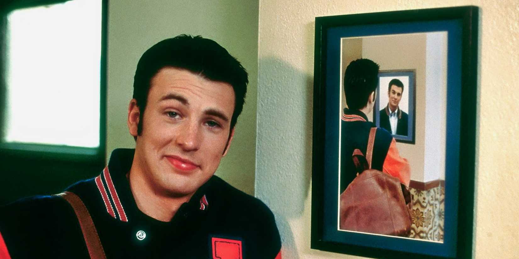 Chris Evans smiles while standing next to a photograph from Not Another Teen Movie