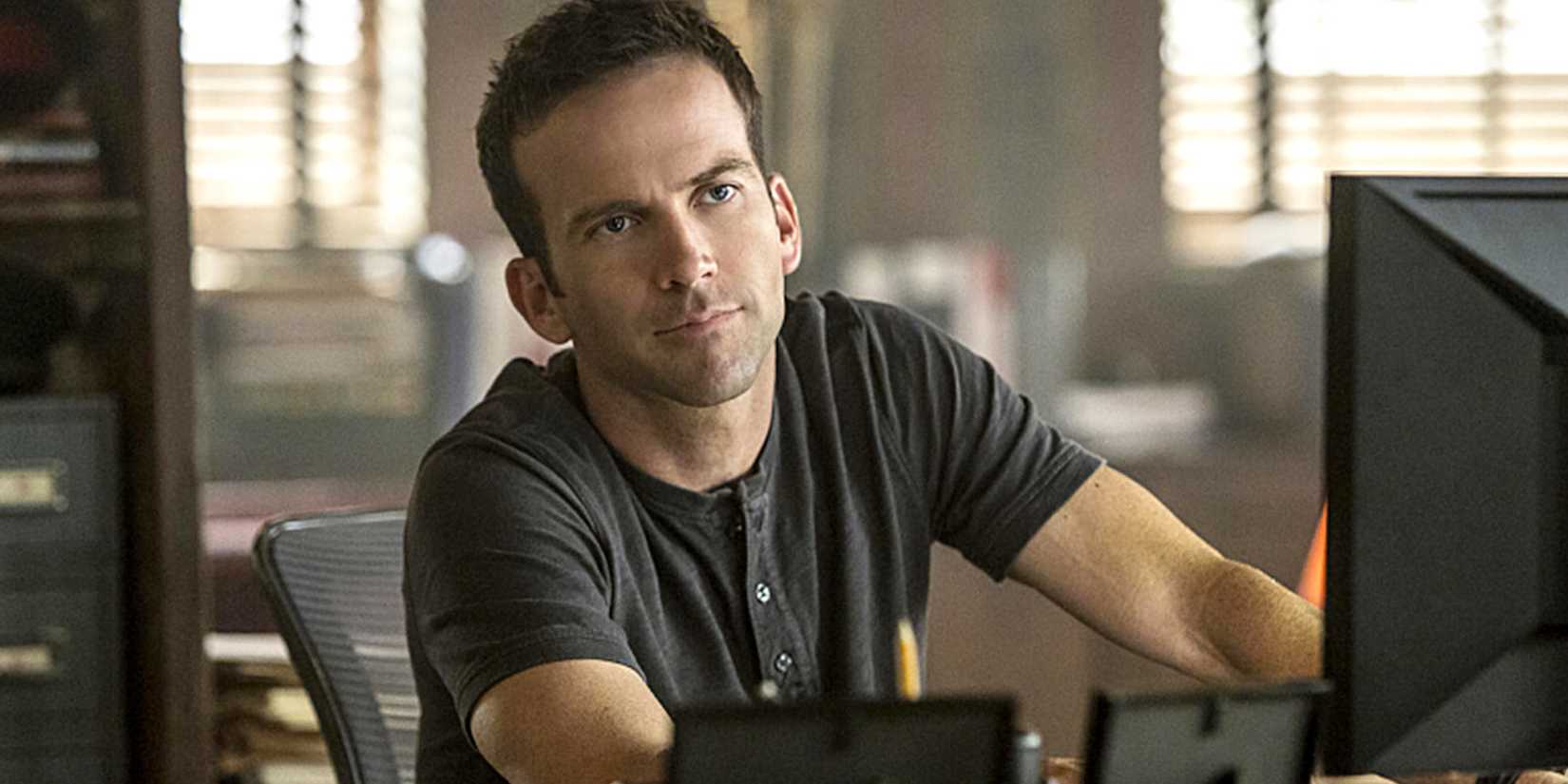 Chris LaSalle sitting behind a computer in NCIS: New Orleans.